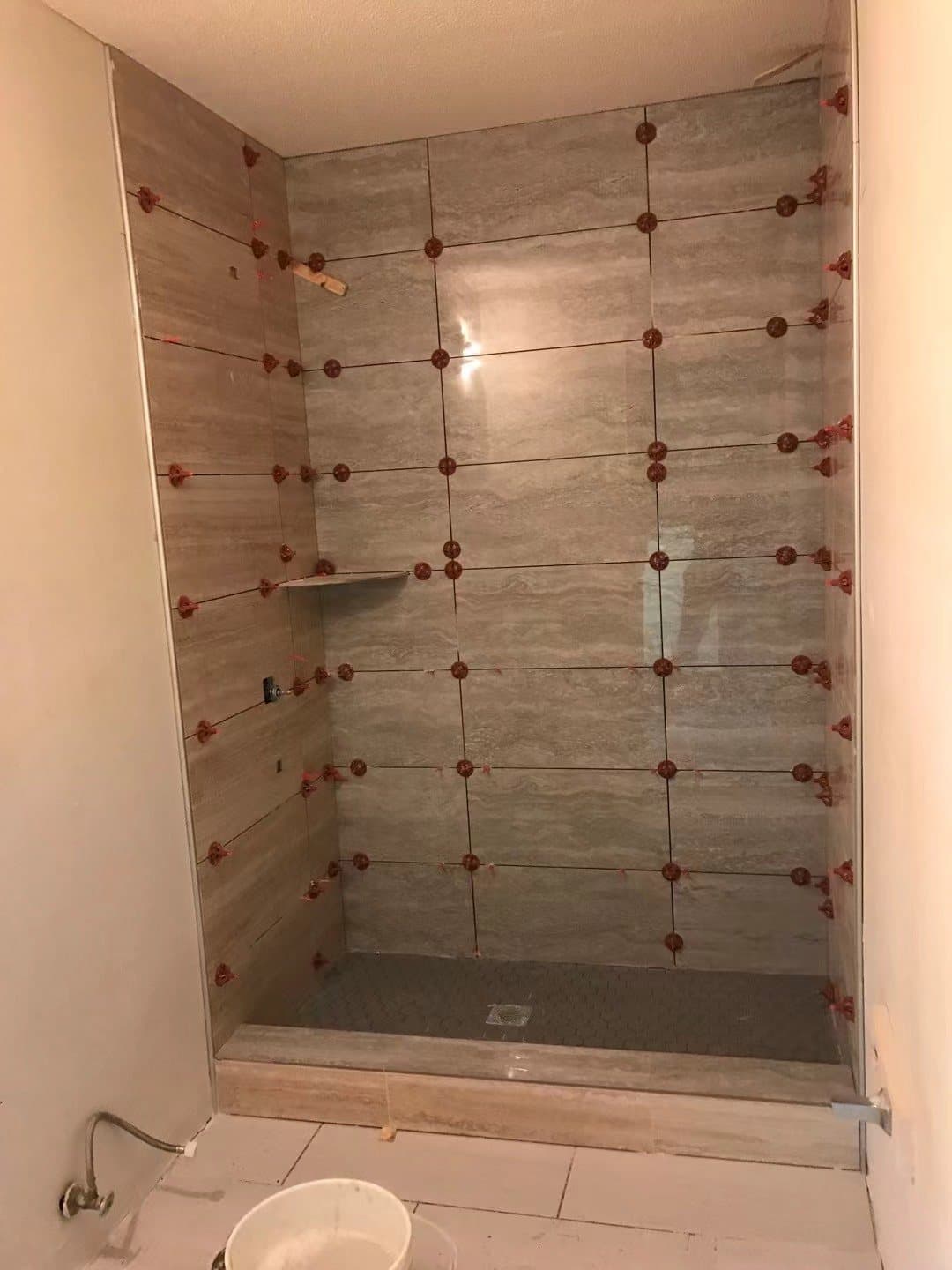 Leveling clips holding every tile flush while it sets